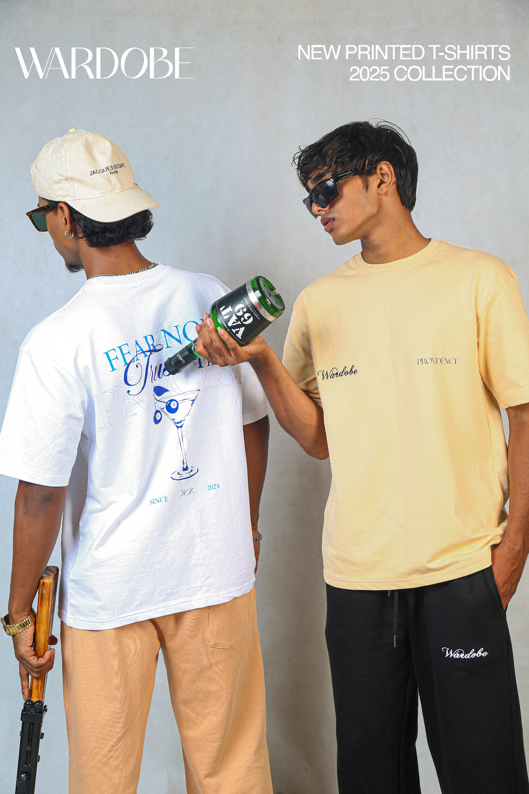 "Wardobe 2025 collection poster featuring new printed t-shirts. One model in a white graphic t-shirt with beige pants, another in a beige t-shirt with black pants."